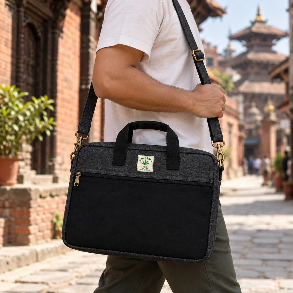 Whole black hemp laptop bag carried at hip level with the adjustable strap